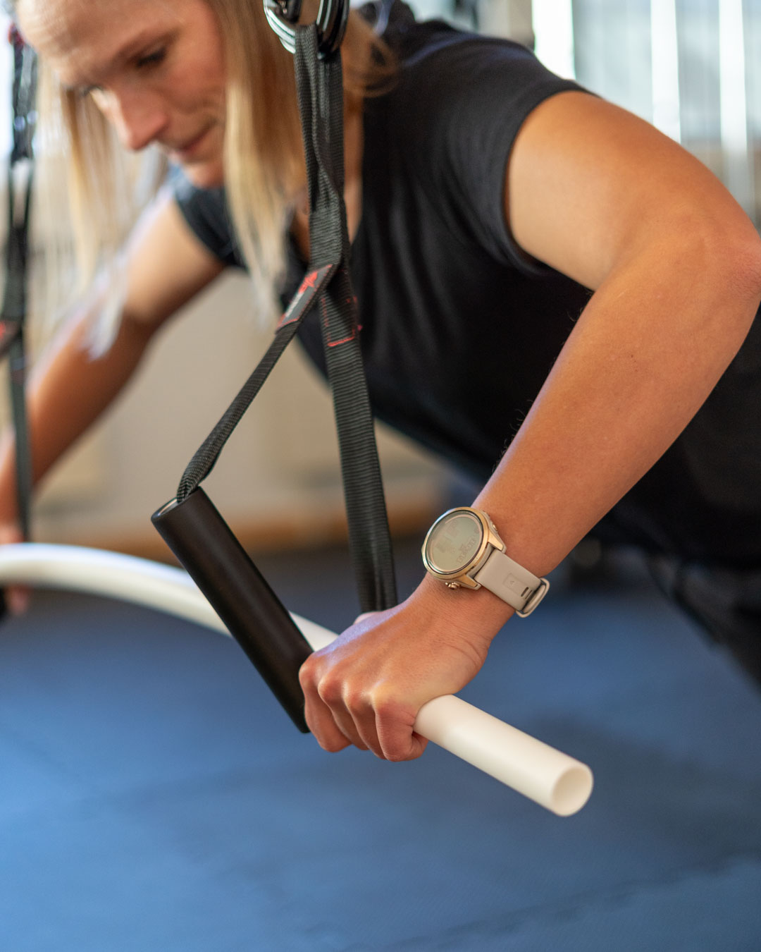 Sportphysiotherapie Eine Patientin führt eine Stützübung an einem Stab durch, um die Position beim Mountainbiken zu simulieren