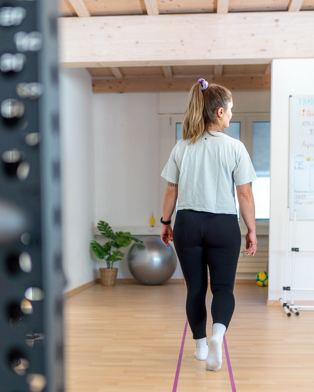 Schwindeltherapie FGA Patientin geht zwischen zwei Linien geradeaus und dreht dabei den Kopf nach links und rechts.