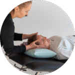 Therapeutin führt Supine Roll Test an Patientin durch