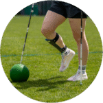 Patientin spielt einen Fussball. Am rechten Bein trägt sie eine Fussheberschiene.